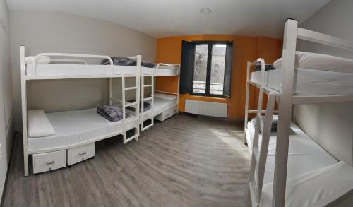 a dorm room with three bunk beds and a window at ALBERGUE SAN MARCOS in Palas de Rei