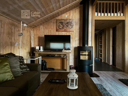 a living room with a couch and a tv at Modern New Sports Chalet at Sjusjøen in Ringsaker