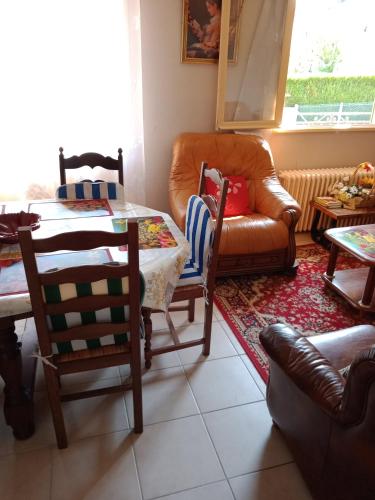 a living room with a table and a couch at Maison entière Garage et parking in Montluçon