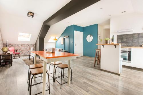 a kitchen and dining room with a table and chairs at La Maison Jaurès - Le Brooklyn in Liévin