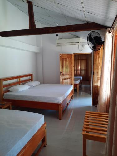 a room with two beds and a bench in it at 1906 Park View in Anuradhapura