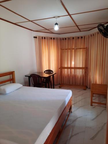 a bedroom with a bed and a table in it at 1906 Park View in Anuradhapura