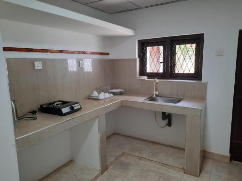 a kitchen with a counter and a sink and a window at 1906 Park View in Anuradhapura