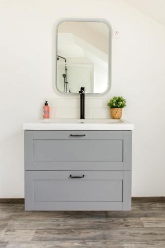 a bathroom with a white sink and a mirror at La Maison Jaurès - Le Brooklyn in Liévin