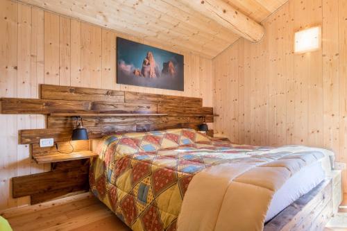 um quarto com uma cama num quarto com paredes de madeira em Baita Dani em San Martino di Castrozza