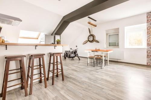 a kitchen with a counter and stools in a room at La Maison Jaurès - Le Brooklyn in Liévin