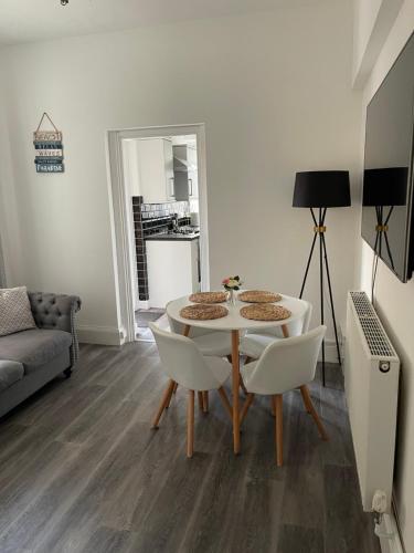 a small living room with a table and chairs at Impeccable 2-Bed Apartment in Eastbourne in Eastbourne