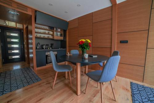 a dining room with a table and blue chairs at Waterfall Glamping Cabin in Bihać