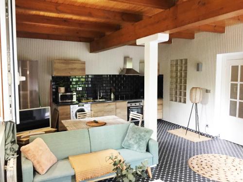 a living room with a blue couch and a kitchen at Getxo Garden Houses - The Suite in Getxo