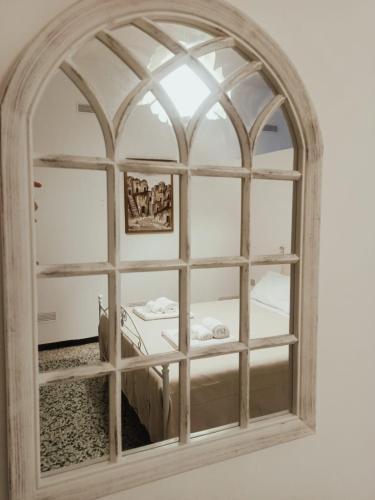 a mirror with an arched window in a room at UltimoCasale in Matera