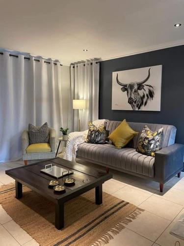 un soggiorno con divano e tavolo di Lux apartment Plett a Plettenberg Bay