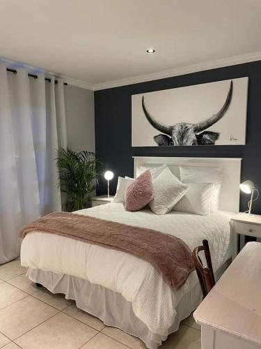 a bedroom with a bed with a picture of a bull at Lux apartment Plett in Plettenberg Bay