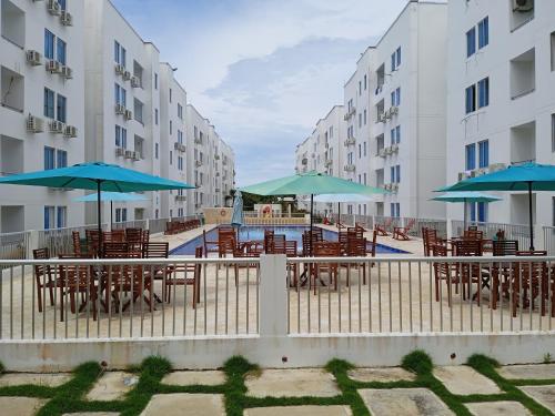 una piscina con mesas y sombrillas en un patio en Apartamento en caribe campestre, en Coveñas