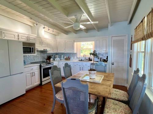a kitchen with a wooden table with chairs and a dining room at Write on the Bay, a Waterfront Retreat in Coastal Alabama in Fairhope
