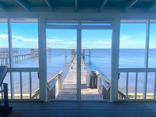a room with a view of a dock and the ocean at Write on the Bay, a Waterfront Retreat in Coastal Alabama in Fairhope
