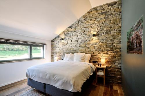 a bedroom with a stone wall and a bed at Le Domaine de Bra in Bra