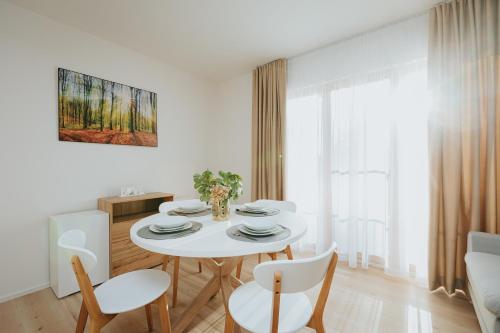 una sala da pranzo bianca con tavolo e sedie bianchi di Apartmán BALIN X31 a Dolný Kubín