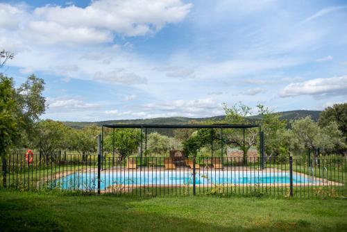 a swimming pool behind a fence in a yard at Finca El Azahar in Trujillo