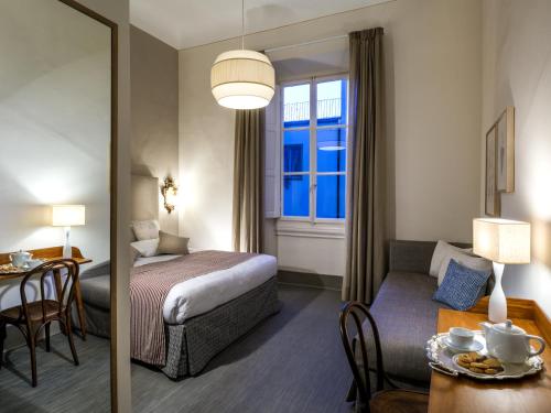a hotel room with a bed and a table and a couch at Alfieri9 in Florence
