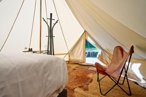 a tent with a chair in front of it at Le Domaine de Bra in Bra