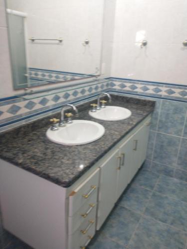 a bathroom with two sinks and a large mirror at Casarão Primavera in Serra Negra