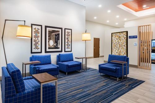 a waiting room at a hospital with blue chairs and tables at Holiday Inn Express & Suites - Lincoln Downtown by IHG in Lincoln