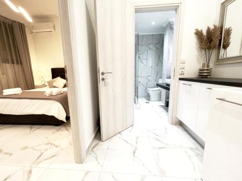 a white room with a bed and a bathroom at Apparlia Athens Luxury Apartment near Acropolis in Athens