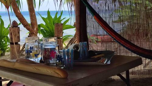 a table with glasses on top of it with the ocean at Te Fitii Garden & Beach in Fare