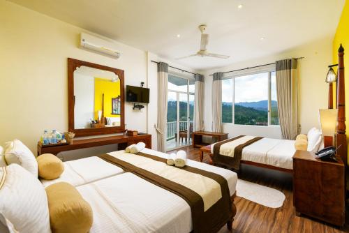 a hotel room with two beds and a mirror at Morning Dew Boutique Hotel Ella in Ella