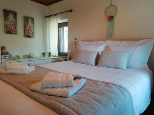 sypialnia z dużym łóżkiem z dwoma ręcznikami w obiekcie Cosy lake house, μια ανάσα πριν τη λίμνη w mieście Kalyvia