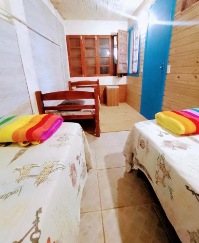 a room with two beds and a chair in it at Hostel Aroeira do campo in Florianópolis
