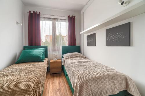 um quarto com 2 camas e uma janela em Apartament Milion Rynek Sienny Stare miasto Apartamenty No.1 em Szczecin