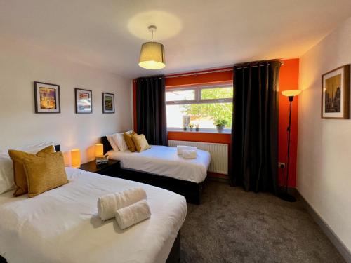 Habitación de hotel con 2 camas y ventana en Curzon House One - Great for Contractors or Family Holidays en Cleethorpes