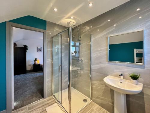 a bathroom with a glass shower and a sink at Curzon House One - Serene Escape Cottage in Cleethorpes
