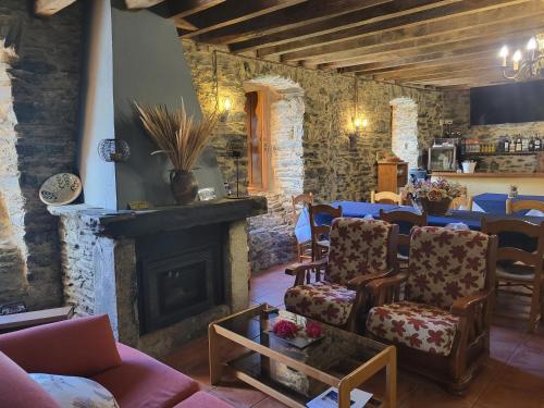 a living room with chairs and a fireplace at Hotel Rural LA CÁRCEL in Murias de Paredes