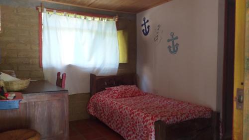 a bedroom with a red bed and a window at Granja Los Conejos in Ramiriquí