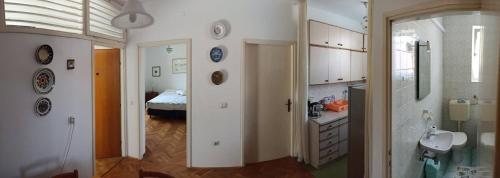 a bathroom with a sink and a room with a bed at Apartments Slavica - free WiFi in Vodice