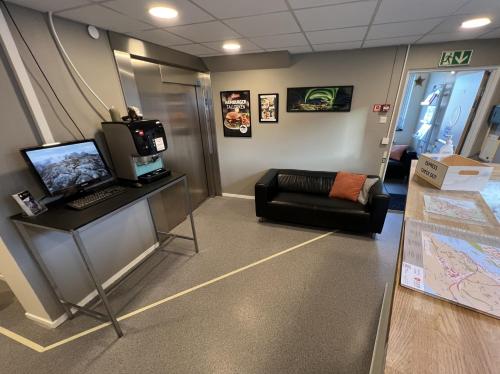 a waiting room with a computer and a couch at Bodø Hostel & Motel in Bodø