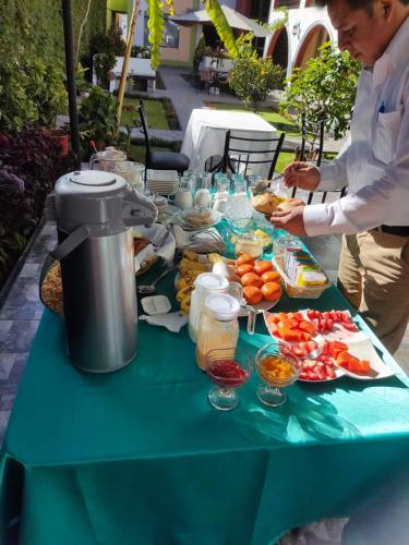 a man standing at a table with food on it at Casa Baraquel in Arequipa
