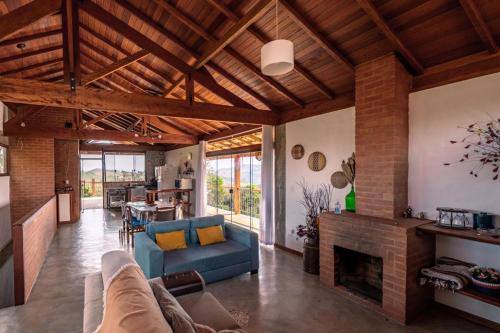 un salon avec un canapé bleu et une cheminée dans l'établissement Villa do Sol, à Conceição da Ibitipoca