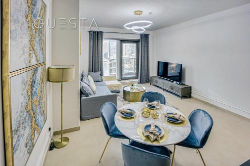 a living room with a table and blue chairs at Sparkle Tower, Dubai Marina in Dubai