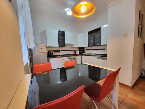 a kitchen with a table and orange chairs at Apartment Sablicevo - Near the Beach in Rijeka