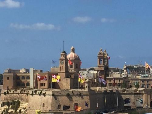 a view of a city with flags and a building at Casa Maria Tereza in Cospicua
