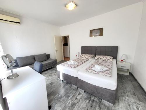 um quarto com uma cama e um sofá em Apartment Evie - Central Historical Quarter em Rijeka