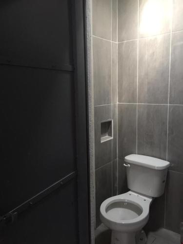 a bathroom with a white toilet in a stall at Hostal La Piedra in Matlapa