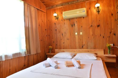 a bedroom with a bed with two towels on it at Tahtavilla Pansiyon in Cıralı