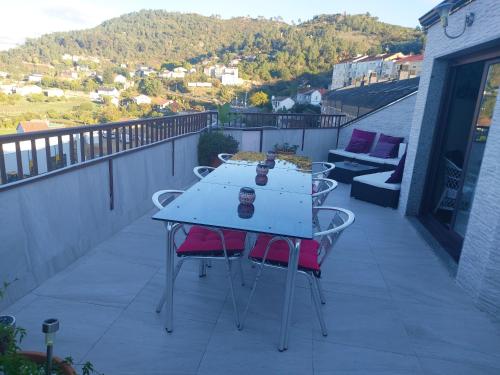 d'un balcon avec une table et deux chaises. dans l'établissement Duplex grandes cristaleras impresionantes vistas, à Ourense