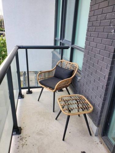 une chaise en osier assise sur le balcon d'un bâtiment dans l'établissement Midtown 4 bedroom home Free Wi-Fi and parking, à Toronto