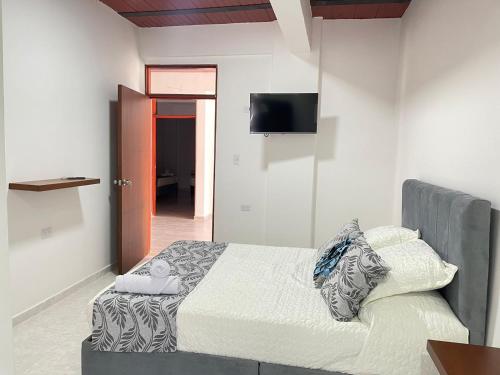 a bedroom with a bed and a flat screen tv at Casa Hotel Estelar in Villavieja