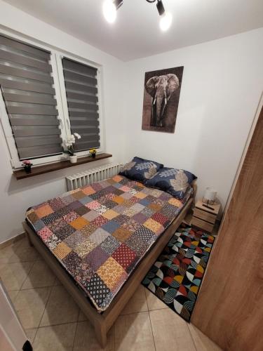 a bedroom with a bed with a quilt on it at Apartament Leon in Wałbrzych
